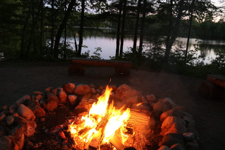 Cinnamon Lodge Quebec fire pit at night near lake