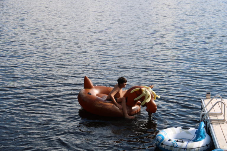 boy on moose water toy at Quebec lake cottage