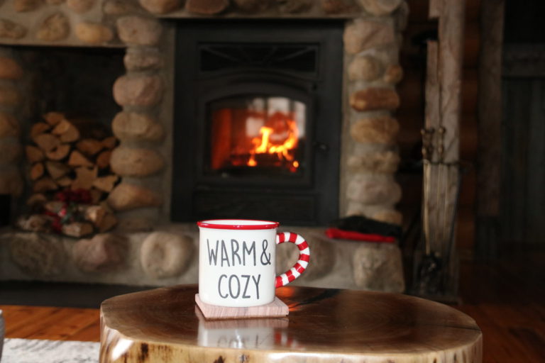 warm and cozy mug in front of fireplace in log cottage rental Quebec