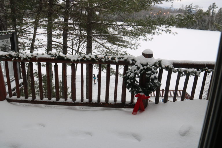 snowy deck of log cottage