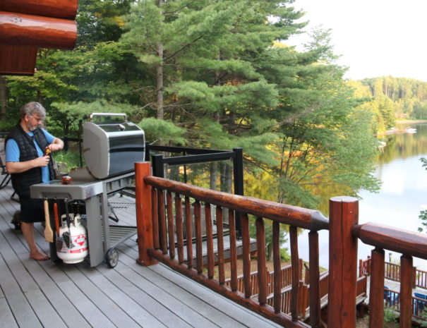 man barbequing on log deck