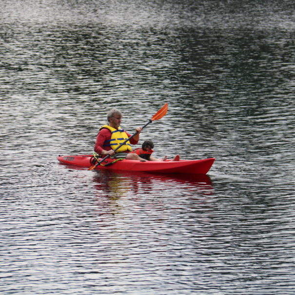 man and dog kayaking quebec lake cottage