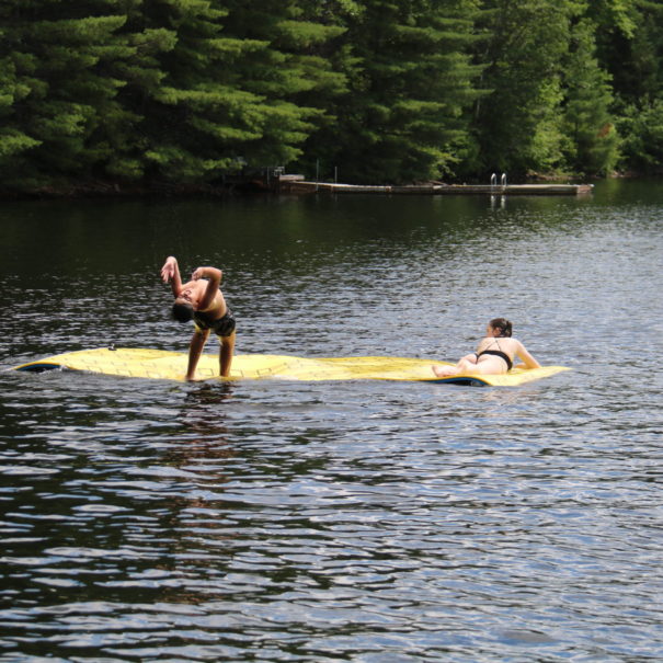 kid jumping off yellow water mat