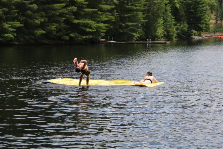 kid jumping off yellow water mat